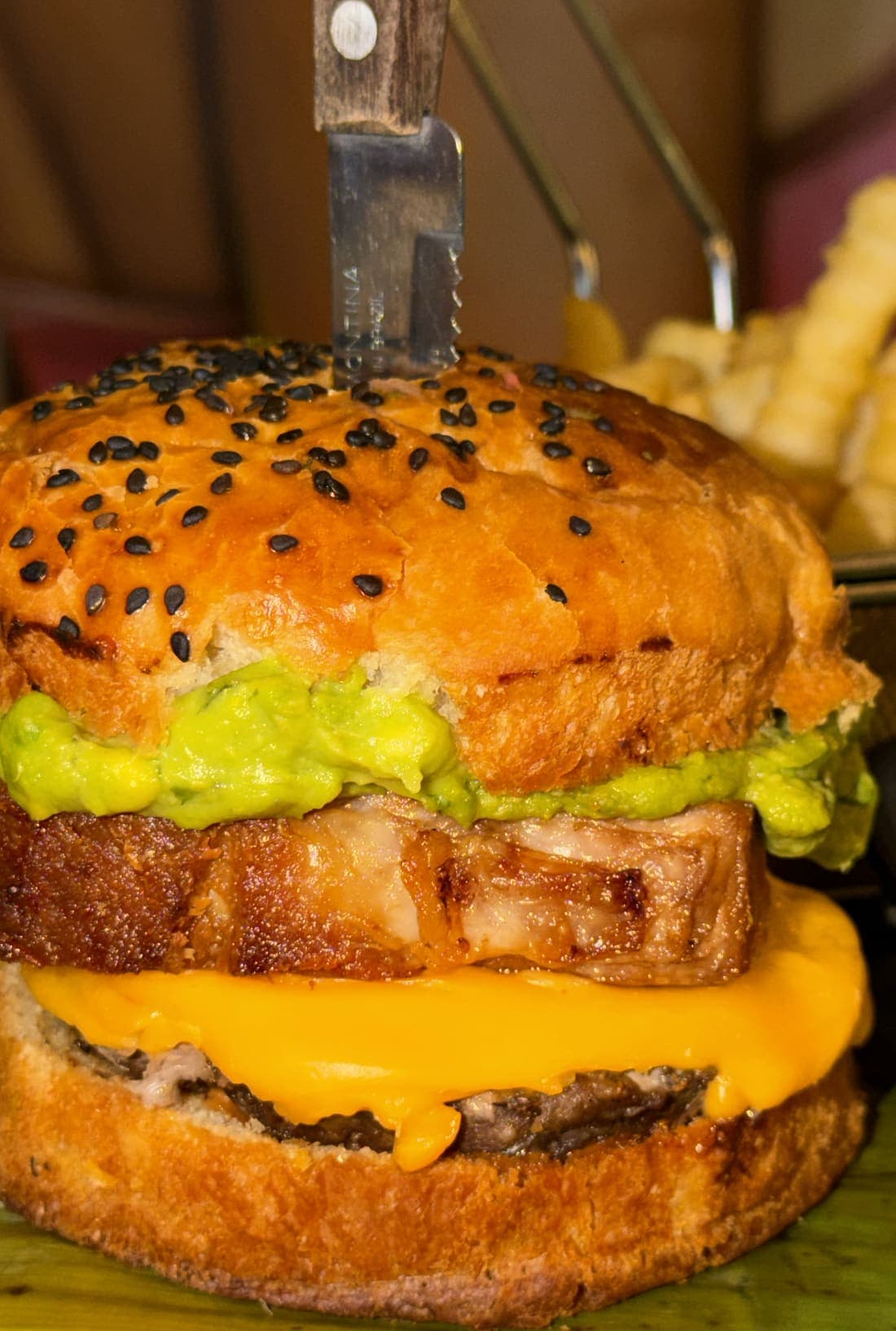 La Berraca: Res artesanal sazonada en casa, y chicharrón de pork belly horneado por dos horas. Sobre pan amasado y horneado en casa, con queso fundido, guacamole fresco y nuestra salsa de la casa. Con papas a la francesa.