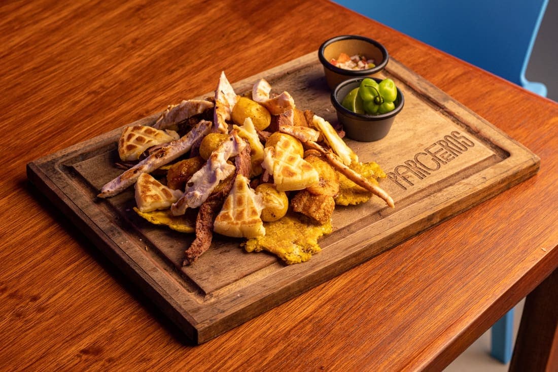 Picada Montañera: Chicharrón crocante, chorizo jugoso, arrachera y pollo • arepa de queso, patacones, yuca frita y papa criolla.